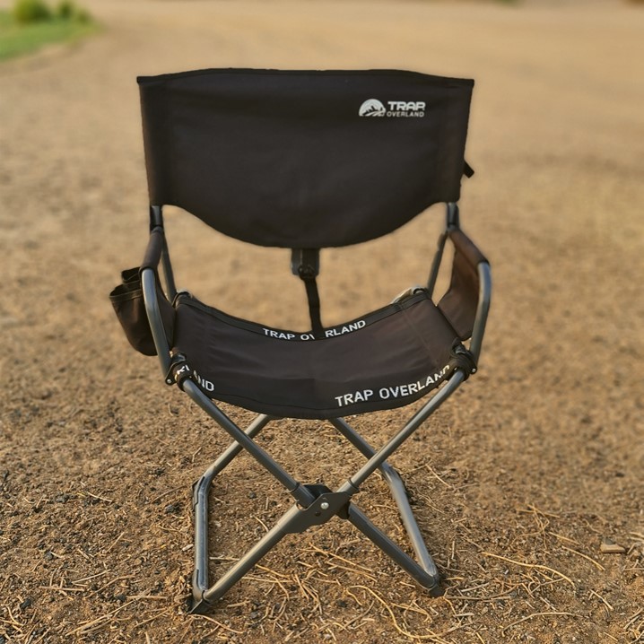 Portable folding chair placed on a dirt ground.