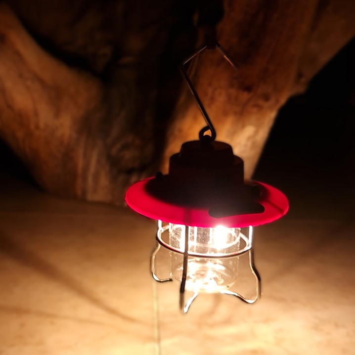 A red lantern with a red hat on it.