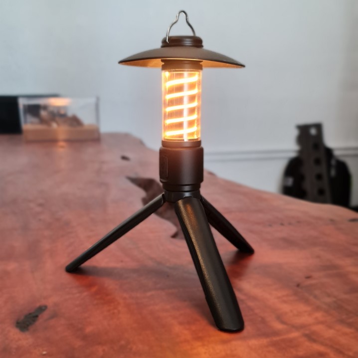 A small lamp on top of a wooden table.
