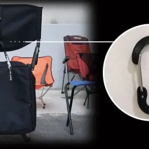 A black TRAP Overland Directors Chair is set up with its carry bag partially visible. Similar chairs in orange and red are in the background. An inset features a black TRAP Overland carabiner clip.