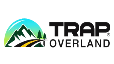 Logo with a stylized mountain and two trees on the left, a yellow road curving through. To the right, bold black text reads TRAP OVERLAND. The mountain scene is set against a circular green and blue gradient background.