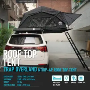 A car with the N-Trip 2 and 4 person RTT, a black roof-top tent featuring a ladder for easy access, is set up in a city parking area. The text provides size and weight specifications of the product.